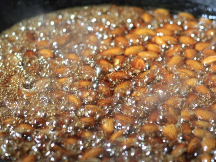 Almonds cooking in oil in a cast-iron pan