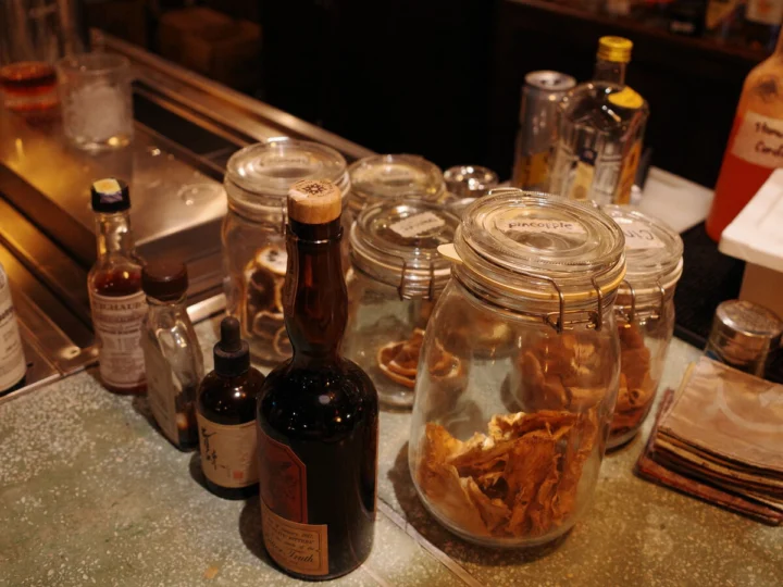 Bottles and jars on a bar counter in warm light