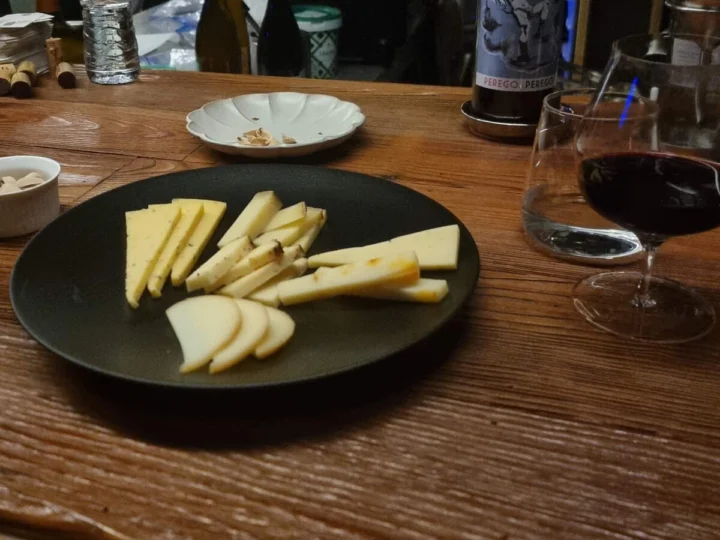 Cheese and a glass of red wine on a bar