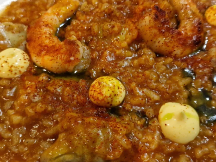 A creamy rice with prawns on a white plate
