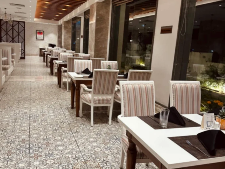 A long row of laid tables on a tiled terrace