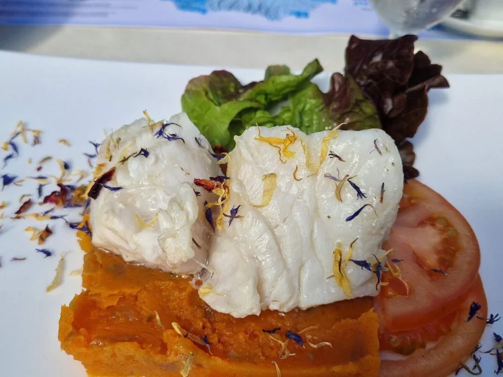 White fish on a tomato base with salad leaves
