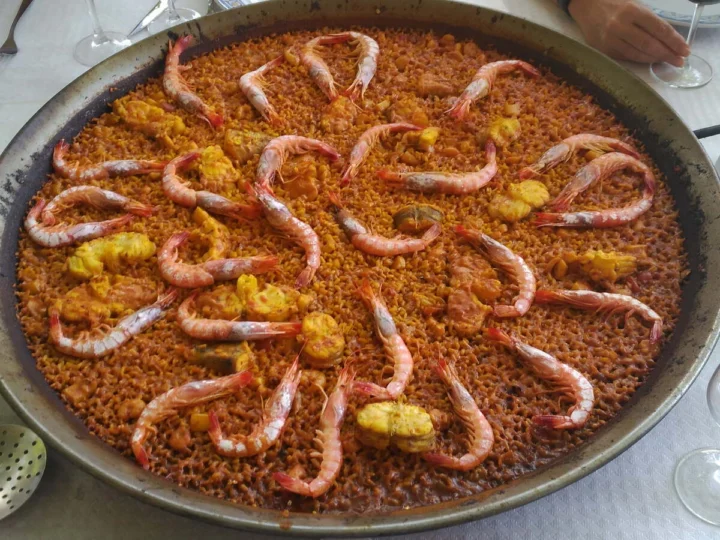 A paella with prawns on a restaurant table
