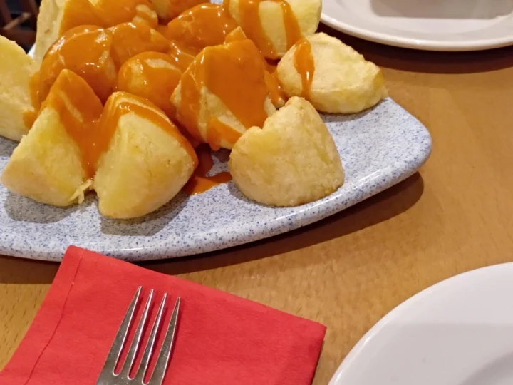 Fried potatoes with a spicy sauce on a plate